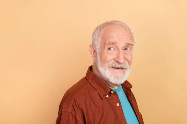 Foto de bonito velho homem penteado cinza olhar promo desgaste camisa marrom isolado no fundo cor bege — Fotografia de Stock