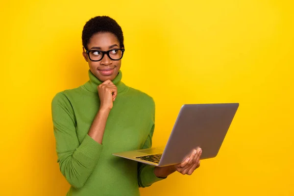 Photo of pretty dreamy trans woman wear green turtleneck typing device hand chin empty space isolated yellow color background — Stockfoto