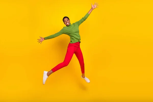 Foto de engraçado muito curto cabelo senhora vestida de gola alta verde andando saltando alto isolado cor amarela fundo — Fotografia de Stock