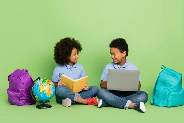 Portrait of attractive pre-teen cheery friends friendship doing homework lesson distance classes isolated on green color background — 스톡 사진