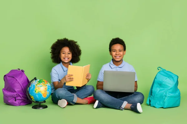 Portrait of attractive pre-teen cheery friends friendship doing homework lesson remote distance subject isolated on green color background — Stockfoto