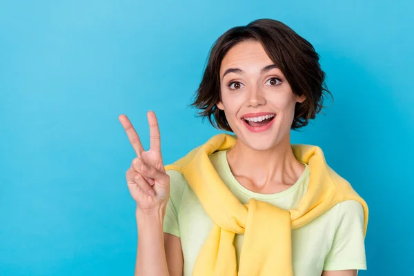 Photo of sweet excited woman wear green t-shirt smiling showing v-sign isolated blue color background — Fotografia de Stock