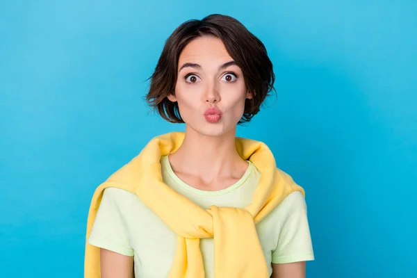 Photo of impressed millennial brunette lady blow kiss wear yellow t-shirt isolated on blue color background — Stockfoto