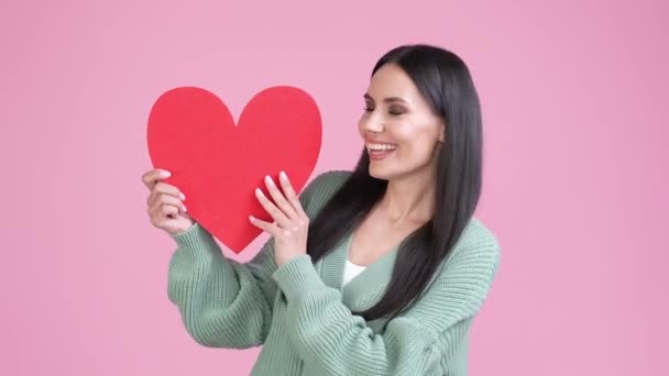 Nette Dame erhalten rote Postkarte Herz isoliert pastellfarbenen Hintergrund — Stockvideo