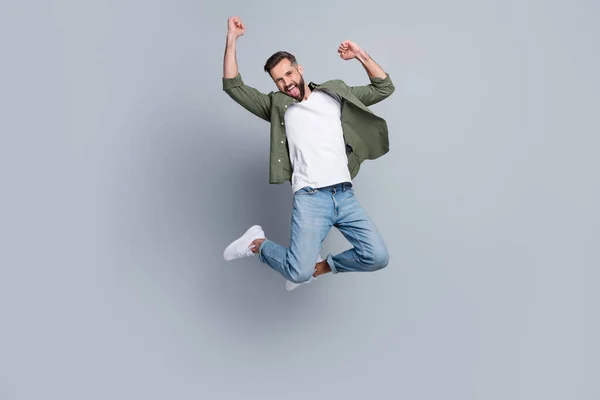 Full length body size view of attractive cheerful guy jumping having fun rejoicing isolated over grey pastel color background — Stock Fotó