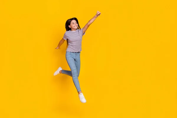 Full size photo of young cheerful girl jump fly power look empty space isolated over yellow color background — Stok fotoğraf