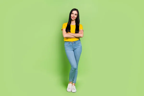 Foto de alegre dama encantadora vestido amarillo camiseta manos plegado aislado color verde fondo —  Fotos de Stock