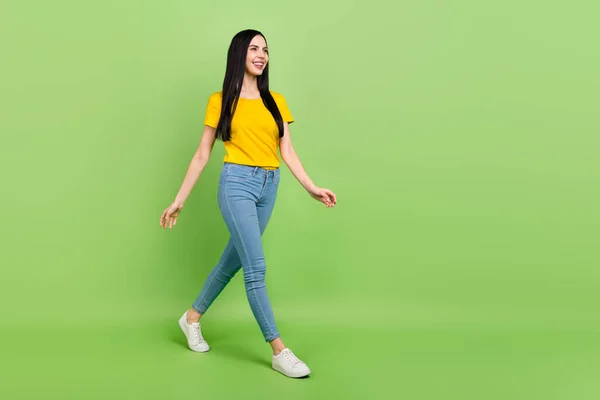 Full length profile portrait of adorable satisfied lady walking look empty space isolated on green color background — Fotografia de Stock