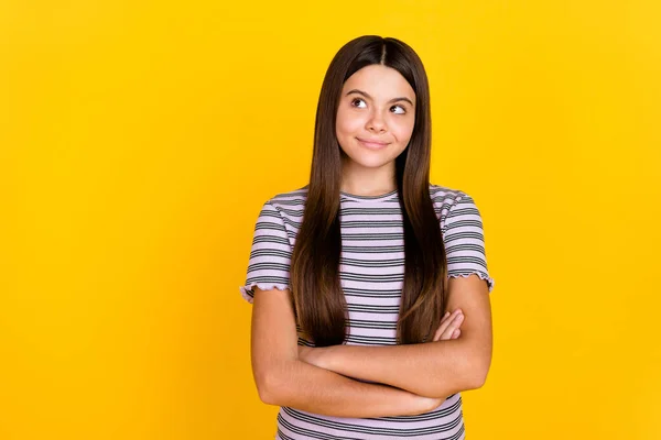 Retrato de atraente alegre curioso de cabelos compridos menina dobrado braços pensando cópia espaço isolado sobre brilhante cor amarela fundo — Fotografia de Stock