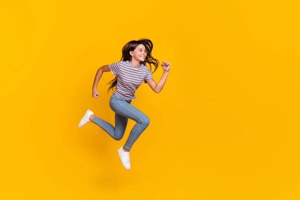 Full size profile side photo of young girl jump runner motion rush speed look empty space isolated over yellow color background — Zdjęcie stockowe