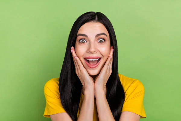 Foto de encantadora senhora impressionado vestido amarelo t-shirt braços bochechas boca aberta isolado cor verde fundo — Fotografia de Stock