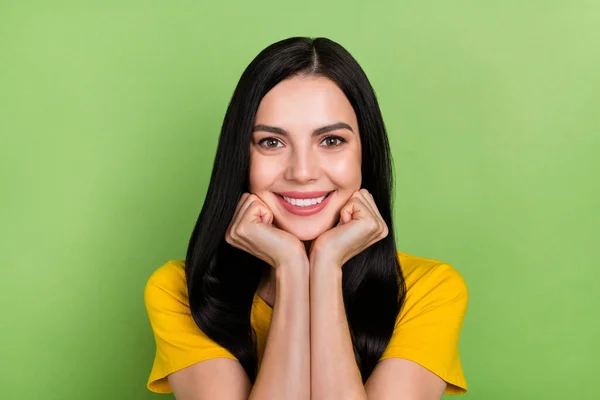 Photo of sweet dreamy woman wear yellow t-shirt arms cheeks smiling isolated green color background — Foto Stock