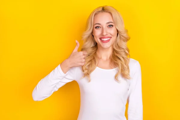 Фото красивої солодкої молодої жінки в білій сорочці, що показує великий палець вгору ізольований жовтий колір фону — стокове фото