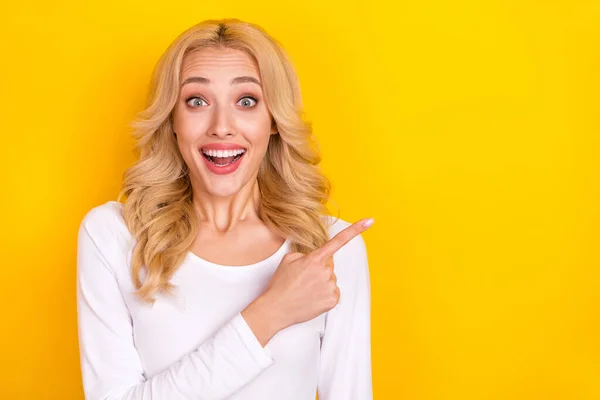 Photo of impressed cute young woman wear white shirt pointing empty space isolated yellow color background — kuvapankkivalokuva