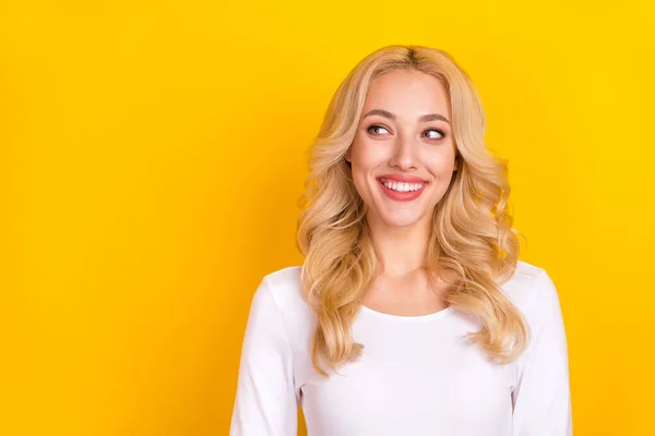 Fénykép csinos álmodozó hölgy öltözött fehér ing mosolygós látszó üres tér elszigetelt sárga szín háttér — Stock Fotó
