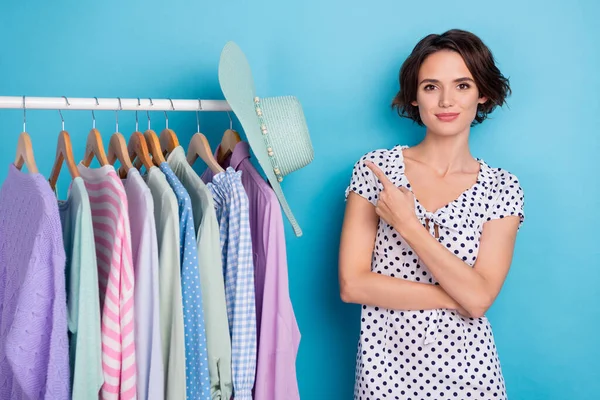 Photo of attractive lady indicate finger store assortment garment cloakroom isolated on blue color background — Stockfoto