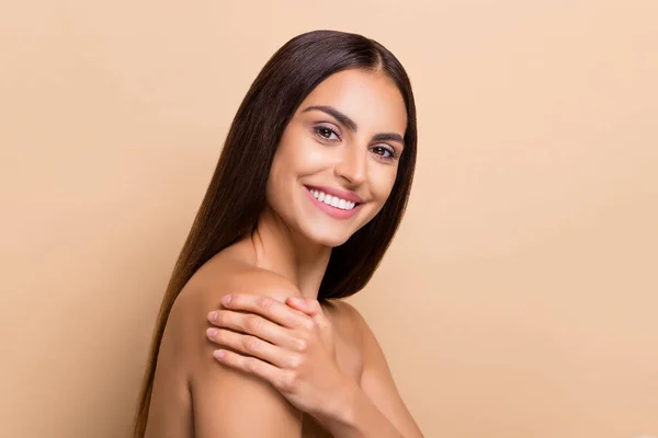 Profile side view portrait of attractive cheery girl touching flawless skin copy space isolated over beige pastel color background — Stockfoto