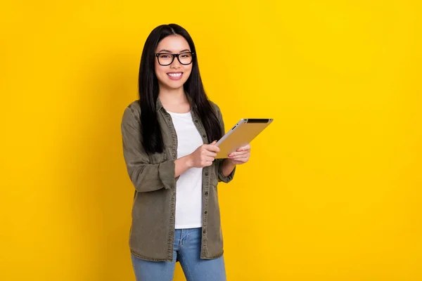 Photo of boss millennial brunette lady hold tablet wear eyewear khaki shirt isolated on yellow color background — 스톡 사진