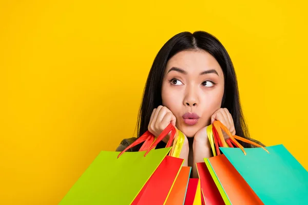 Photo of impressed millennial brunette lady do shopping look promo isolated on yellow color background — Stok fotoğraf