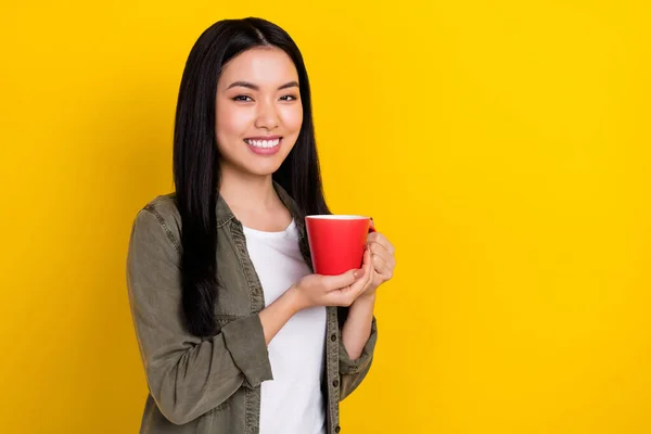 Foto de jovem morena otimista beber chá desgaste casual pano isolado no fundo de cor amarela — Fotografia de Stock