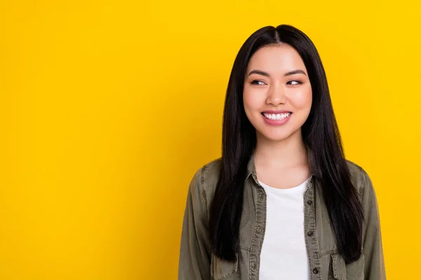 Photo of impressed millennial brunette lady look promo wear khaki shirt isolated on yellow color background — Stock Photo, Image