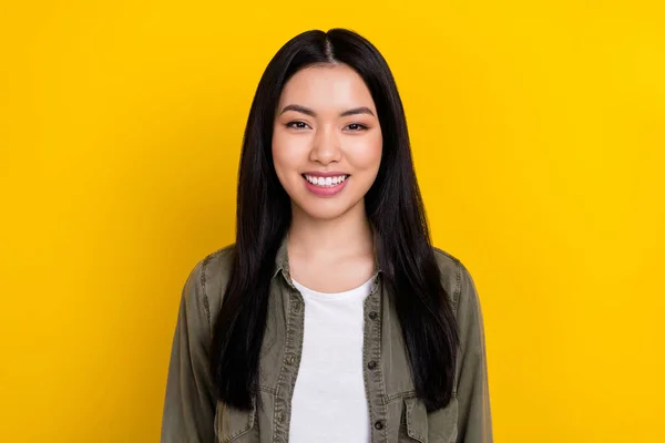 Portrait of young cheerful beaming korean ethnicity female wear khaki jacket isolated on yellow color background — Stockfoto