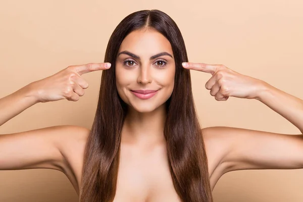 Portrait of attractive cheery long-haired girl showing lift effect eye lenses isolated over beige pastel color background — ストック写真