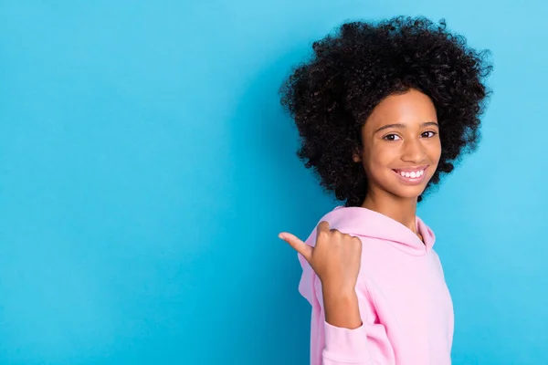 Profil Seitenansicht Porträt von attraktiven fröhlichen buschigen haarigen Mädchen zeigt Kopierraum Anzeige isoliert über helle blaue Farbe Hintergrund — Stockfoto