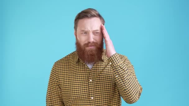 Guy lider frygtelige hovedpine tømmermænd part isoleret blå farve baggrund – Stock-video