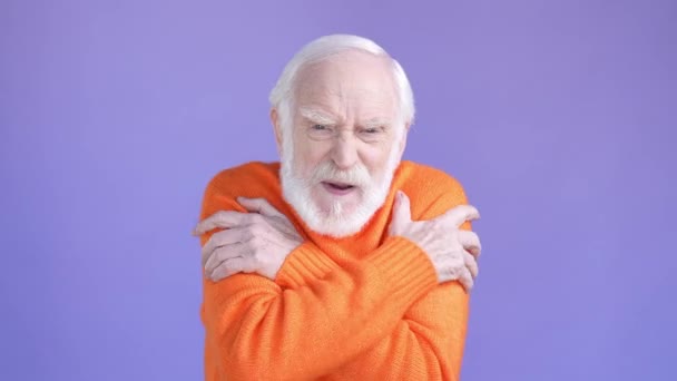 Aged man feel cold woolen clothes isolated violet color background — Stockvideo