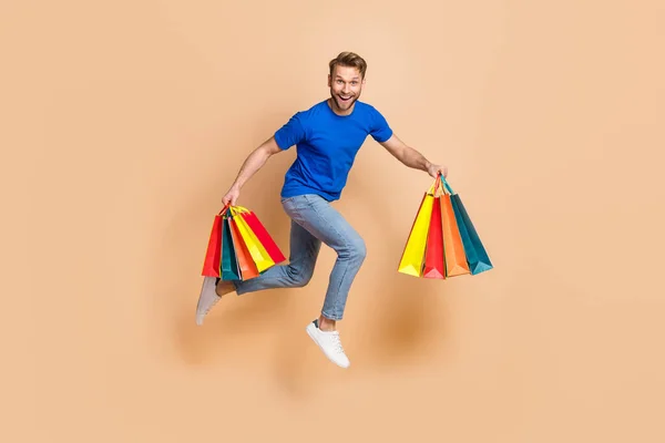 Повнорозмірна фотографія профілю молодого веселого чоловіка енергійний магазин швидкість поспіху знижка ізольована на бежевому кольоровому фоні — стокове фото