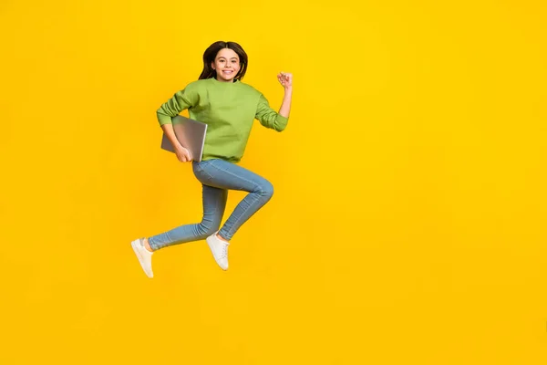 Foto de longitud completa de la joven chica activa jumper rush celebrar portátil aislado sobre fondo de color amarillo —  Fotos de Stock