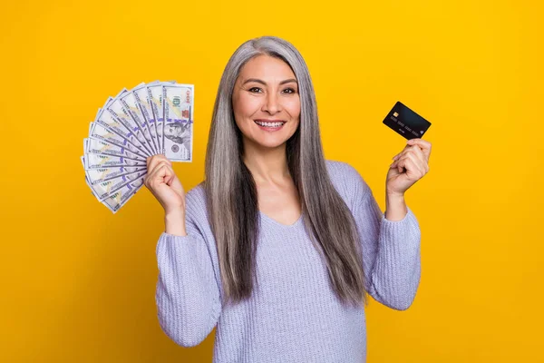 Foto di allegro pensionato positivo femminile in maglia pullover preferiscono pagamento wireless per contanti isolato su sfondo di colore giallo — Foto Stock