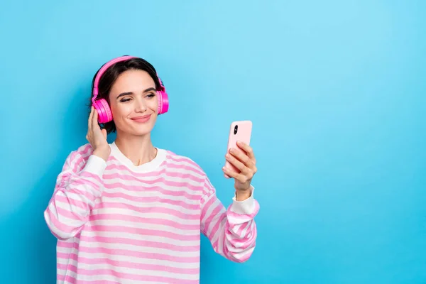 Foto von entzückenden Dame hören Musik online surfen in Smartphone Social Media süchtig isoliert auf blauem Hintergrund — Stockfoto