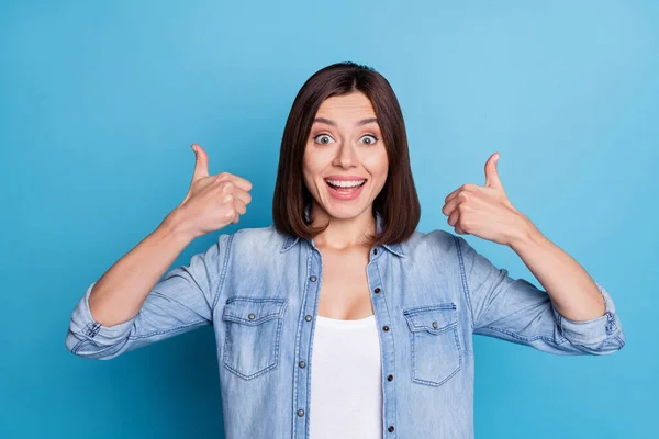 Photo of impressed excited lady dressed denim shirt showing two thumbs up isolated blue color background — Fotografia de Stock