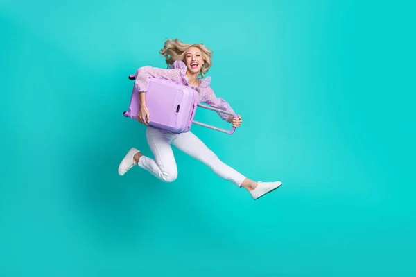Фото милої чарівної жінки, одягненої в фіолетову блузку, стрибає з високим багажем ізольований кольоровий фон зі сльозами — стокове фото