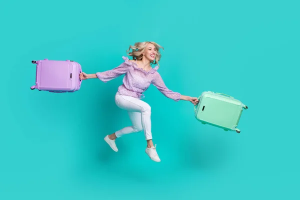 Foto de señora bastante emocionada usar blusa violeta saltar corriendo cheque en la celebración de equipaje aislado color turquesa fondo — Foto de Stock