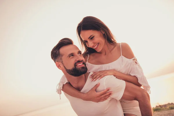 Photo portrait couple laughing together cuddling piggyback wearing white stylish clothes — Stock Fotó