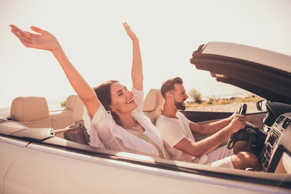 Profile side view portrait of attractive adorable carefree cheerful couple riding car having fun free time outdoors — Stok fotoğraf