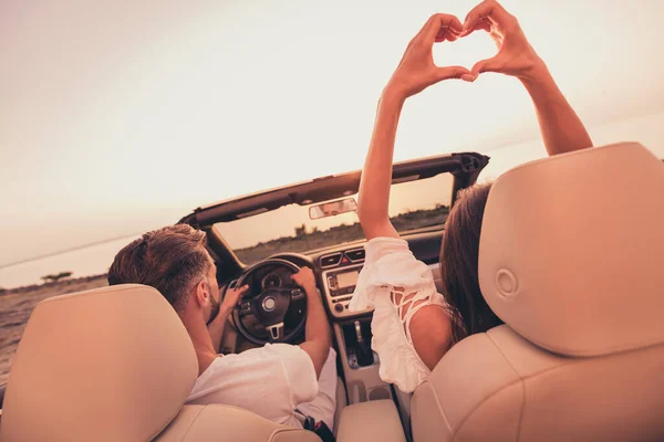 Back rear view photo of young couple ride car landscape adventure show fingers heart symbol love romantic outdoors — Foto Stock