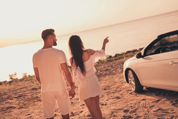 Photo of sweet charming husband wife wear white outfits smiling riding automobile walking holding arms outside country side route — Stok fotoğraf