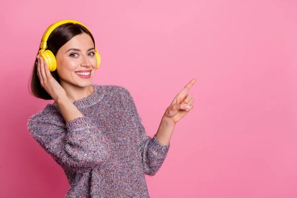 Porträt von attraktiven fröhlichen Mädchen hören Single zeigt Kopie Leerraum wie folgen isoliert über rosa Pastellfarbe Hintergrund — Stockfoto