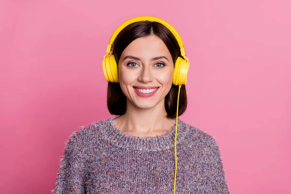 Fotografie rozkošné lesklé ženy nosit svetr žlutá sluchátka s úsměvem izolované růžové pozadí — Stock fotografie