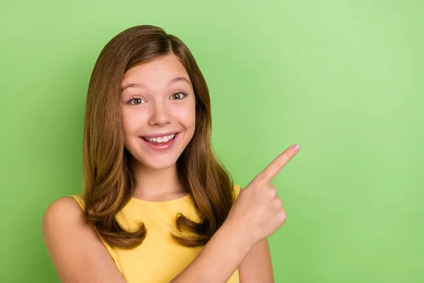 Foto de menina alegre jovem indicar dedo vazio proposição promoção espaço isolado sobre fundo cor verde — Fotografia de Stock