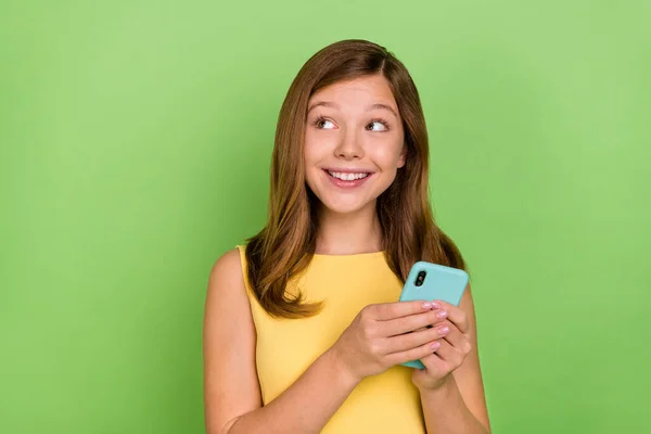 Photo de jeune belle dame regard curieux espace vide utiliser le téléphone mobile repost partager isolé sur fond de couleur verte — Photo