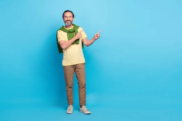 Full size photo of positive cheerful person direct fingers empty space isolated on blue color background — Fotografia de Stock