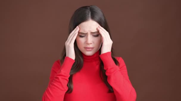 ストレスの女性がひどい頭の圧力を受ける隔離された茶色の背景 — ストック動画