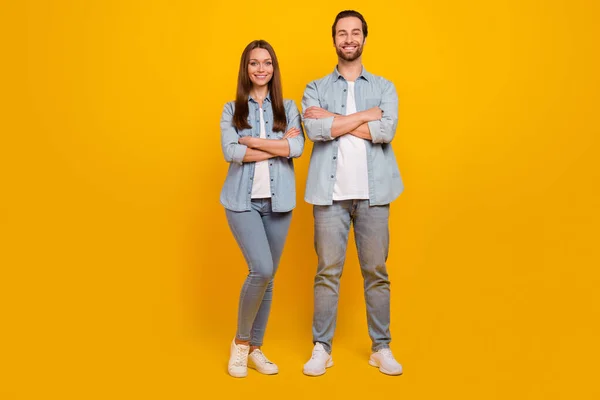 Foto de charmoso irmão irmã alegre vestido camisas jeans braços cruzados sorrindo isolado cor amarela fundo — Fotografia de Stock