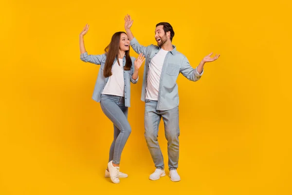 Full length body size view of attractive carefree cheery people dancing having fun isolated over bright yellow color background — Stok fotoğraf