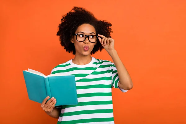 Portrait of attractive funny intellectual wavy-haired girl reading plan touch specs pout lips isolated on bright orange color background — Foto Stock